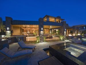 House exterior lit up at night, with patio furniture