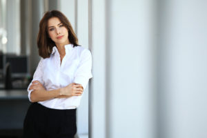 business woman leaning against wall