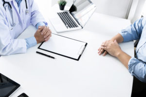 Doctor giving patient advice sitting at desk
