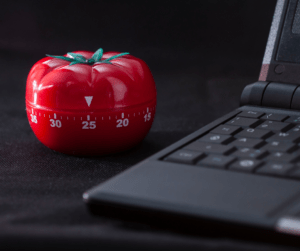 tomato shaped kitchen timer next to computer