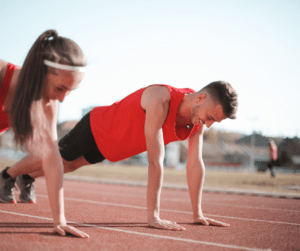 Male & female working out on track smiling